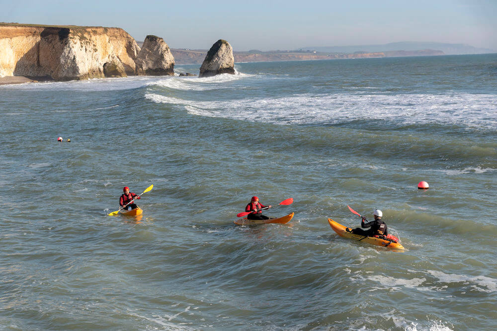 Freshwater Bay, Isle of Wight, England, UK. February 2019. Couple learning to kayak in a slight swell on Freshwater Bay in the west of the Isle of Wight a popular holiday resort.