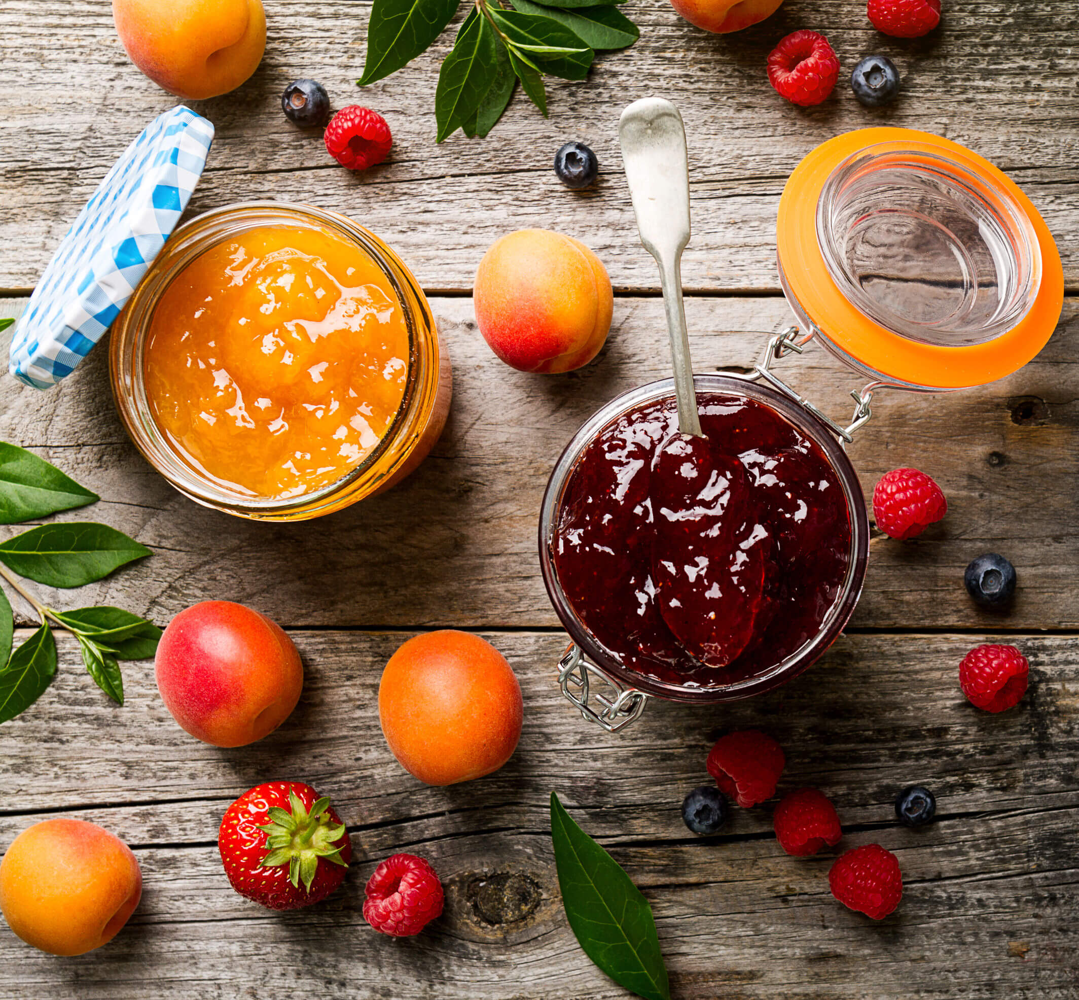 Tasty fruit red strawberry berry jams in glass jar with fruits on wooden table. Closeup. Top View.