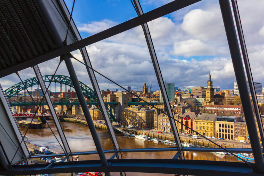 Newcasstle city Skyline through Sage Gateshead windows with River Tyne, Tyne Bridge and other buildings at Newcastle Quayside in view