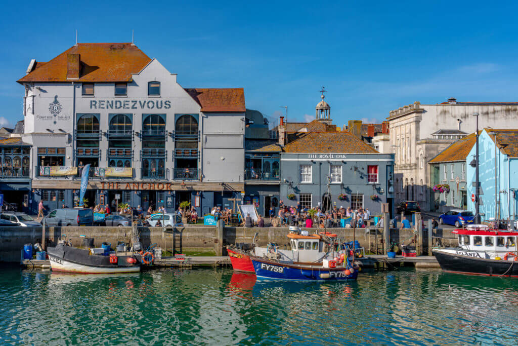 WEYMOUTH, UNITED KINGDOM - AUGUST 30: Traditional British pubs along the waterfront at Weymouth harbour on August 30, 2019 in Weymouth