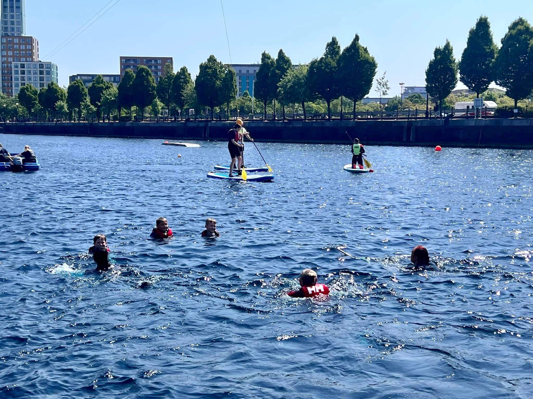 People paddle boarding at Salford Quays, Salford, Manchester 
