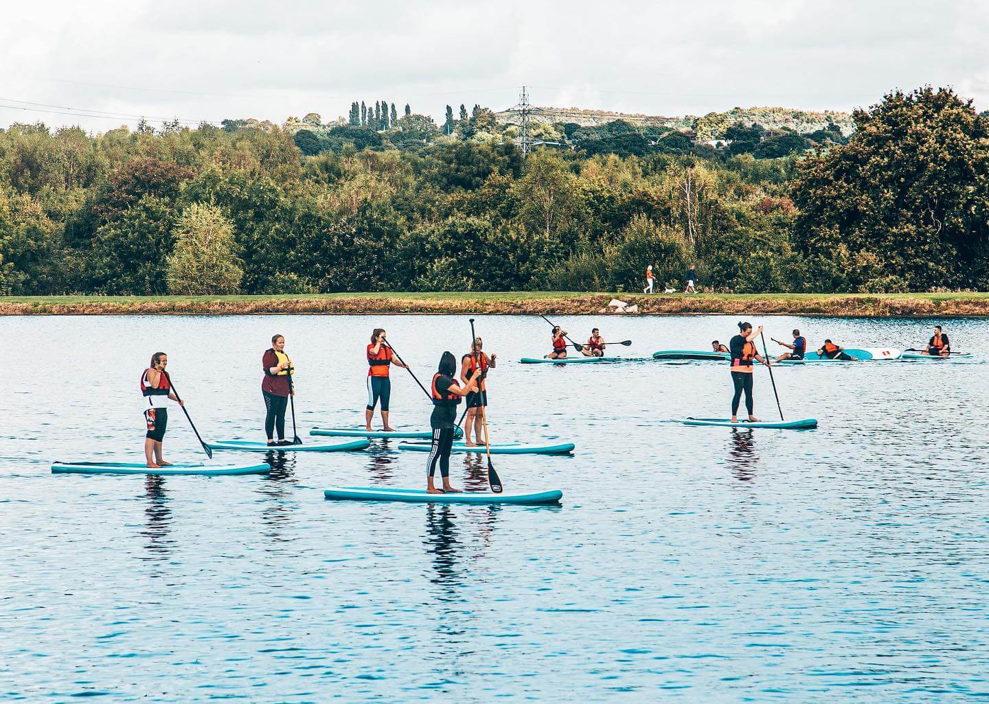 People paddle boarding at Manley Mere in Cheshire, England