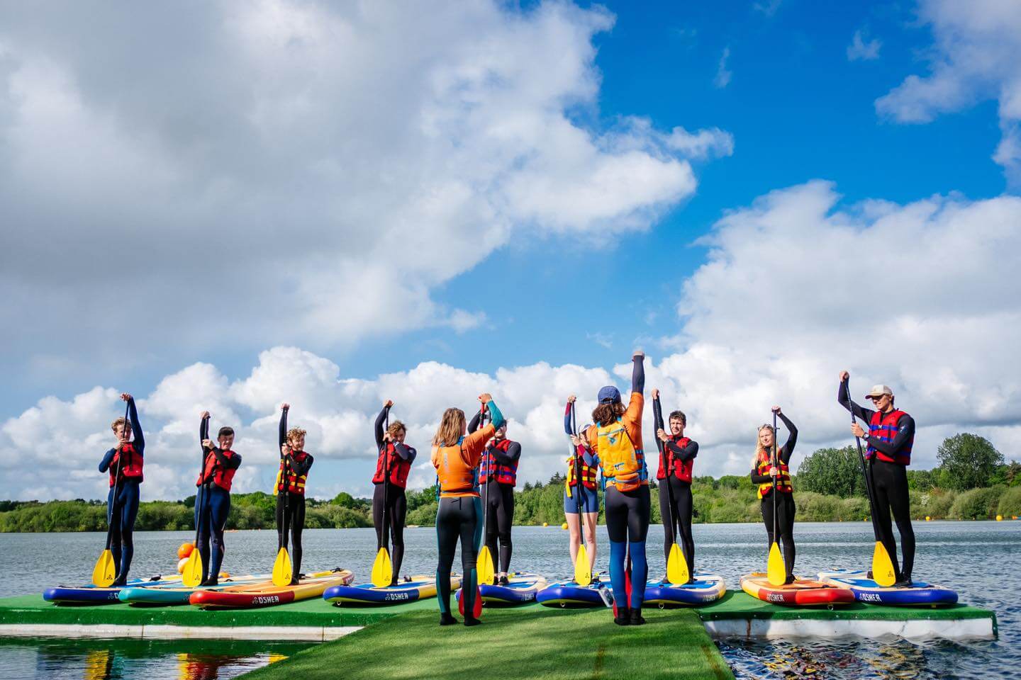 People learning to paddle board at Wild Shore Delamere in Cheshire, England